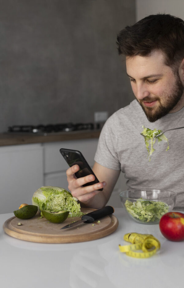 young-man-eating-checking-his-smartphone